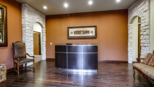 A reception desk in an office building with wood floors.